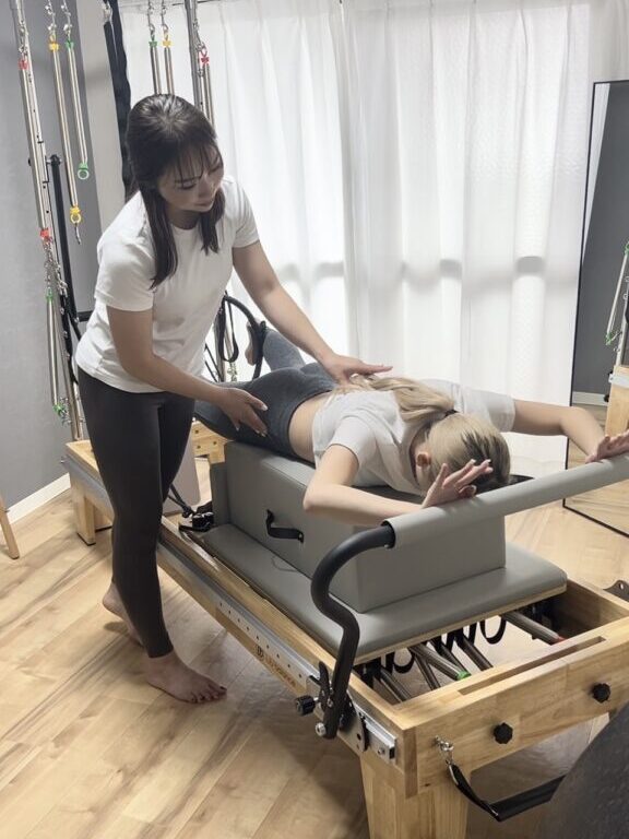 ピラティスマシンでトレーニングしている女性